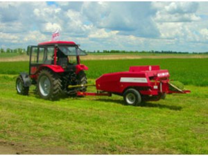 Фото: трактор мтз с прессом на заготовке сена для КРС
